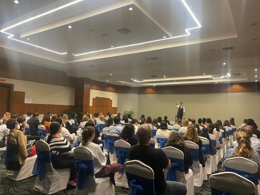 El Dr. Zuluan Orion en una conferencia, ante una sala llena