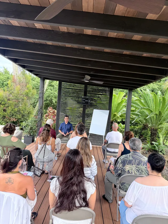 Meditación en grupo bajo una pérgola, en un jardín